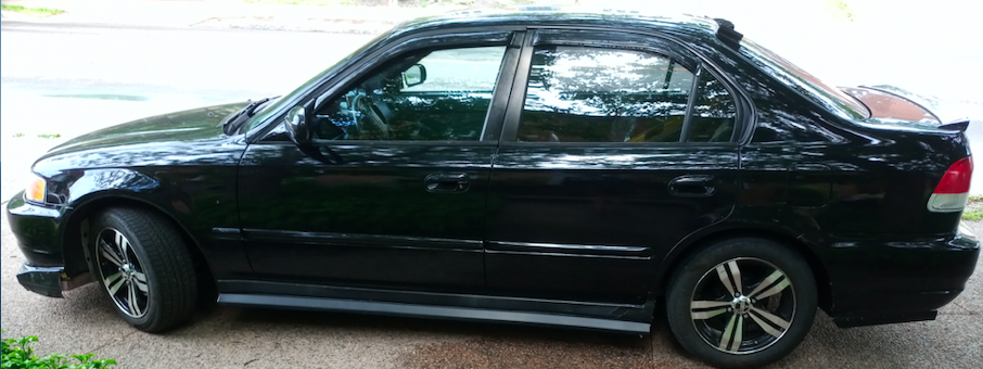 1999 Acura EL driver side profile showing front spoiler, lower side skirt addition, thin rear deck lid spoiler and vortex generators installed at top of rear window.