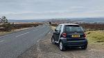 Small car, twisty road, big sky.