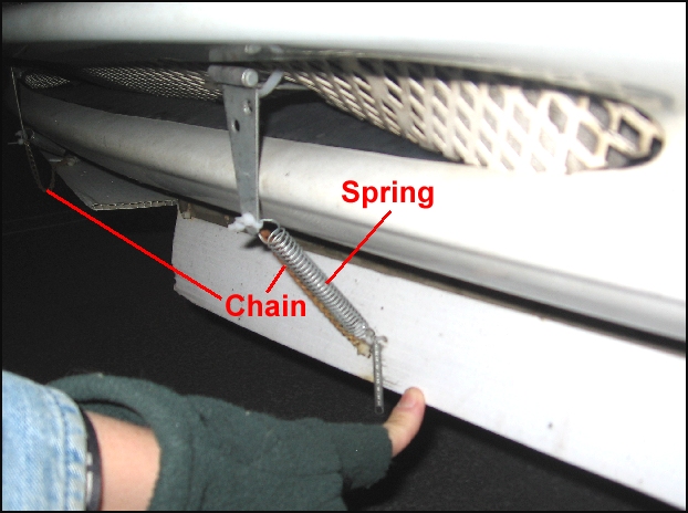 Detail of spring and chain.  Zip ties connect them and act as failure points if the air dam hits something on the freeway.