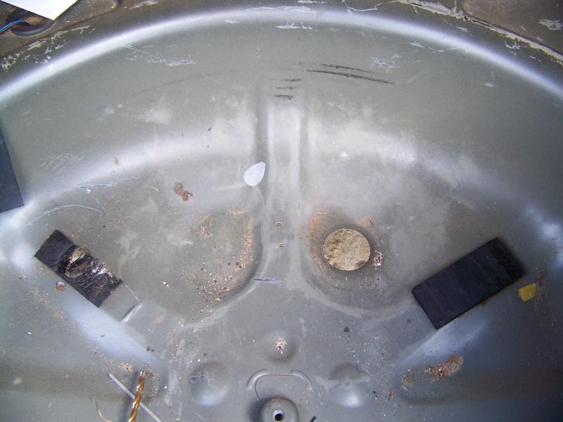 The only perforations made to the steel of the car, located in the spare tire well. It is used to pass a tie rap to hold the corrugated plastic.