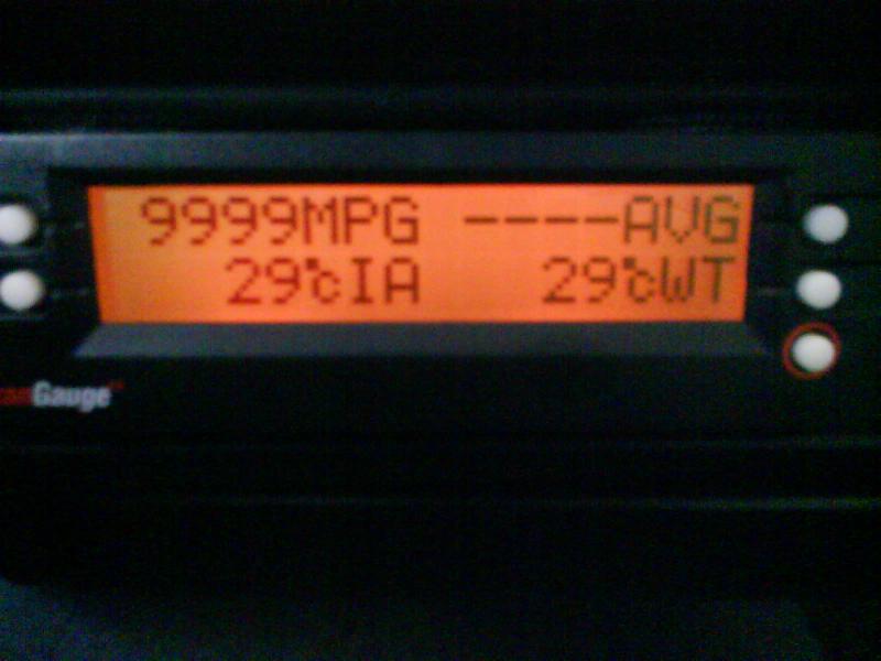 The Scan Gauge II displaying miles per gallon (MPG), average miles per gallon (AVG), intake air temperature (cIA) and coolant temperature (cWT). Both temp readings are in Celsius.

This readout was made at about 7 AM on a summer morning in Puerto Rico with the Key On Engine Off (KOEO). The car was not moving, neither the engine was idling, that's why MPG=9999, since there is no fuel injector pulsation. 

Note that both coolant temp and intake air temp are the same, since the car was completely cold. 

This is the base line to compare any improvement in warming the air intake.